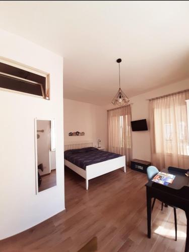 a bedroom with a bed and a table and a mirror at Casetta Sapienza in Gaeta