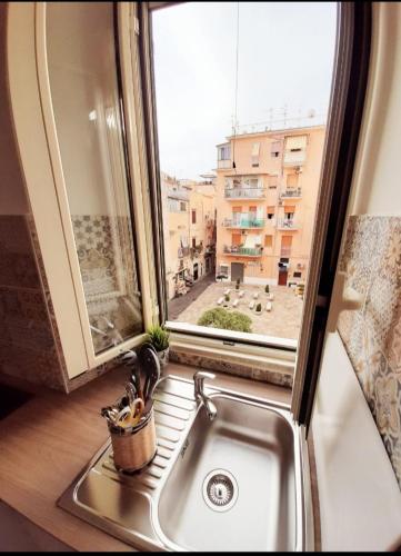 a kitchen sink with a window and a potted plant at Casetta Sapienza in Gaeta
