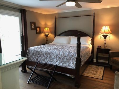 a bedroom with a bed and two lamps and a window at Casa Blanca Boutique Bed & Breakfast in Niagara-on-the-Lake