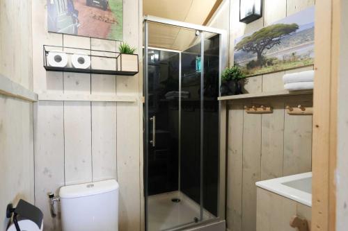 La salle de bains est pourvue d'une douche, de toilettes et d'un lavabo. dans l'établissement Glamping Safarilodge 'Grutte Fiif' met airco, extra keuken op veranda en privé achtertuin, à Grou