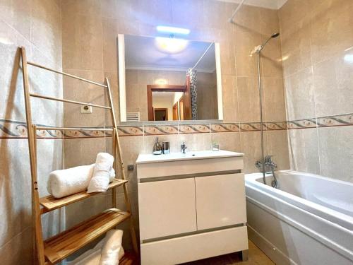 ein Badezimmer mit einem Waschbecken, einem Spiegel und einer Badewanne in der Unterkunft Torreirinha in Torreira