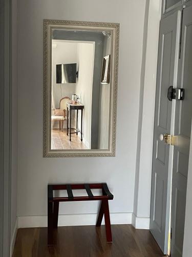 a mirror on a wall with a table in a room at Palacete Encanto Maior in Campo Maior