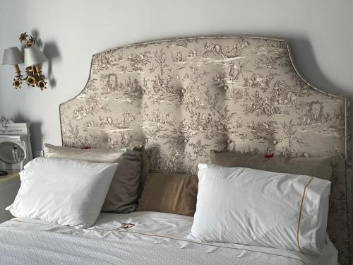 a bedroom with a bed with a large headboard at Palacete Encanto Maior in Campo Maior