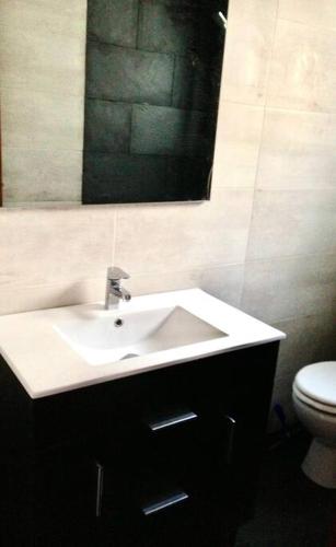 a bathroom with a sink and a toilet and a mirror at LA CARACOLA Benicarló in Benicarló