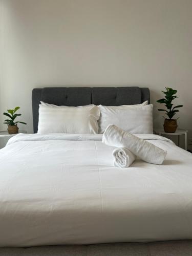 a white bed with white sheets and pillows at Chambers Suites KL in Kuala Lumpur