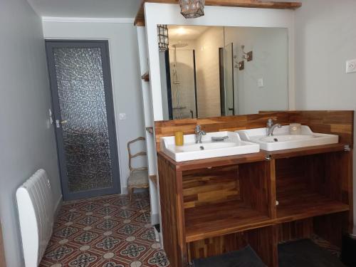 Baño con 2 lavabos y espejo en LA ROSE DES VENTS, en Le Pouget