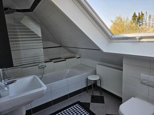 ein Bad mit einem Waschbecken, einer Badewanne und einem Fenster in der Unterkunft Ferienwohnung Haus Rita in Glasau