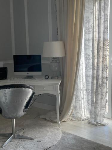 a desk with a computer and a chair next to a window at Palacete Encanto Maior in Campo Maior