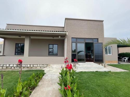 a house with red flowers in front of it at Seafront house in Swakopmund