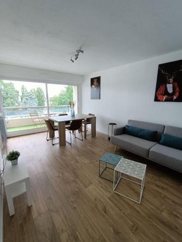 een woonkamer met een bank en een tafel bij Appartement sans vis à vis à 2 min de la rocade in Rennes
