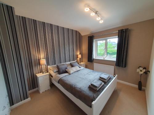 a bedroom with a large bed and a window at Yucca cottage in Kendal