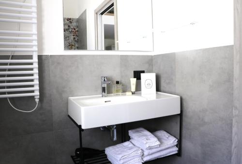 uma casa de banho com um lavatório branco e um espelho. em Elimi Home Appartamenti em Nuova Gibellina