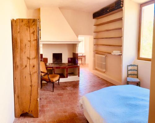une chambre avec un lit et un bureau dans une pièce dans l'établissement Mas Provençal au pied de la sainte Victoire à 8 k d'Aix en provence, à Beaurecueil