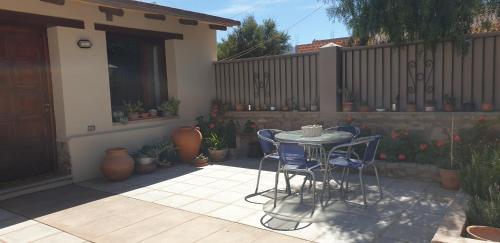 a patio with a table and chairs and a fence at La Casa de los Molles in Tilcara