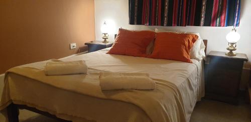 a bedroom with a bed with two pillows on it at La Casa de los Molles in Tilcara