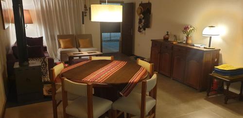 a dining room with a table and a living room at La Casa de los Molles in Tilcara