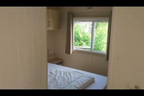 a small room with a bed and a window at Chalet te huur op *****camping Terspegelt 4 personen in Eersel