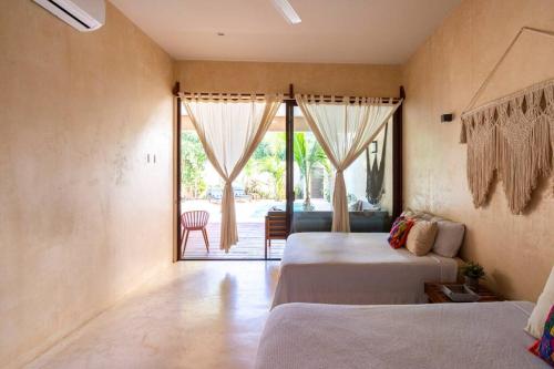 um quarto com 2 camas e uma porta para um pátio em Casa Esperanza Tulum Private Pool em Tulum