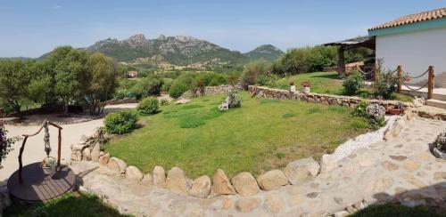 a park with a stone wall and a grass field at Tenuta Petra Manna in Palau