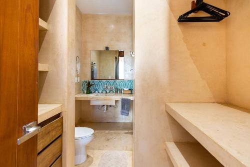 a bathroom with a toilet and a sink and a mirror at Casa Esperanza Tulum Private Pool in Tulum
