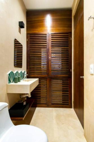 a bathroom with a white toilet and a sink at Casa Esperanza Tulum Private Pool in Tulum