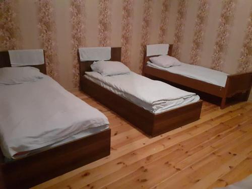two twin beds in a room with wooden floors at Gabala Riverside Villa in Gabala