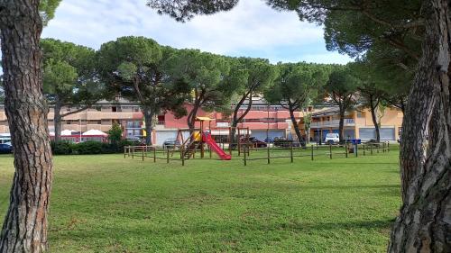 einen Park mit Spielgeräten und Bäumen im Hintergrund in der Unterkunft Aria in Porto Santa Margherita