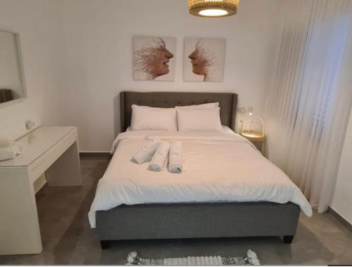 a bedroom with a bed with two pairs of shoes on it at וילה בר בוטיק אילת in Eilat
