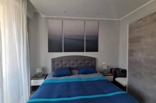 une chambre avec un lit avec des oreillers bleus dessus dans l'établissement Le Mentonnais - Appartement Carré d'Or Menton, à Menton