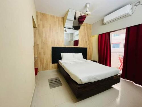 ein Schlafzimmer mit einem Bett und einem roten Vorhang in der Unterkunft Hotel Arcane in Cox's Bazar