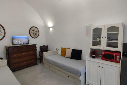 a bedroom with a bed and a desk with a microwave at Dreamer's Secret villa 2 in Emporio Santorini