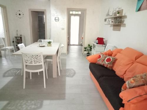 uma sala de estar com um sofá e uma mesa em Casa Paky em Punta Prosciutto