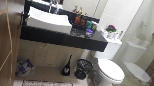 a bathroom with a white toilet and a sink at Casa Linda e Aconchegante in Manaus