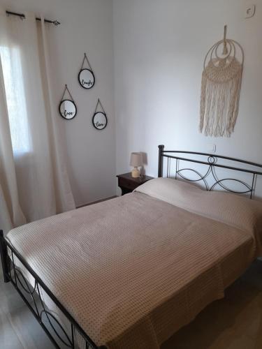 a bed in a bedroom with two clocks on the wall at stegio in Parasporos