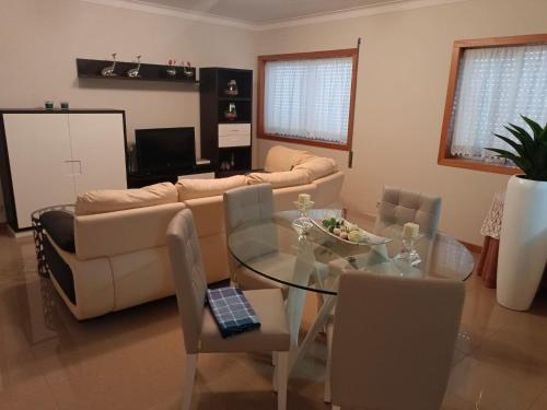 sala de estar con mesa de cristal y sofá en Apartamento Onda Azul, en Vila Praia de Âncora