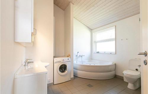 a bathroom with a tub sink and a washing machine at Rubinsen Skovhus in Hasle