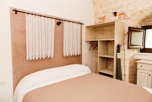 een kleine slaapkamer met een bed en een kast bij Trulli delle Sete in Locorotondo