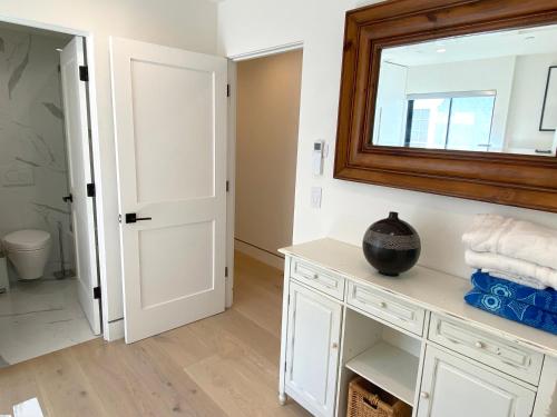 baño con armario blanco y espejo en Bright modern new coastal home with inspiring details in Santa Monica, en Los Ángeles
