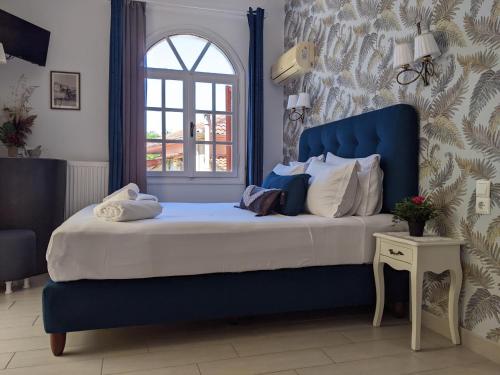 Una cama azul con una cabecera azul en una habitación. en Nafsika Apartments, en Parga