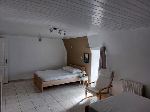 a bedroom with a bed and a chair in it at maison individuelle au calme sur l'Aubrac in Recoules-dʼAubrac