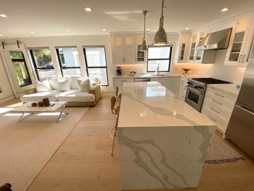 uma cozinha e sala de estar com um sofá e uma mesa em Bright modern new coastal home with inspiring details in Santa Monica em Los Angeles