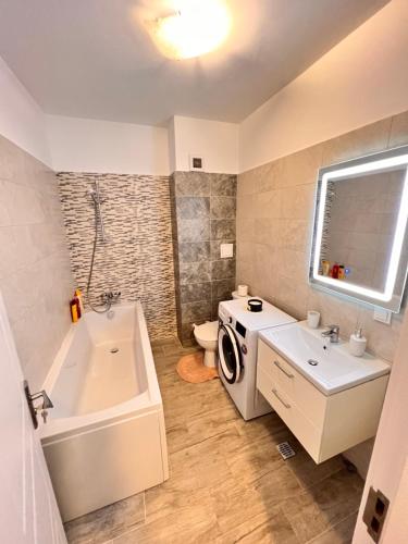 y baño con lavamanos y lavadora. en 2 rooms apartment Airy & Bright Relax, en Iaşi