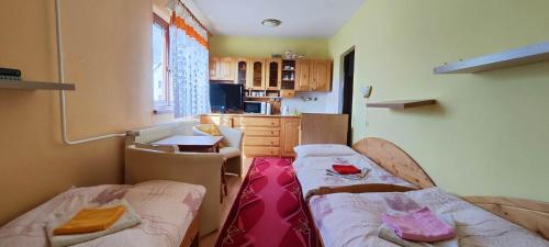 Homestay Machom في أوسكادنيكا: غرفة صغيرة بسريرين ومطبخ