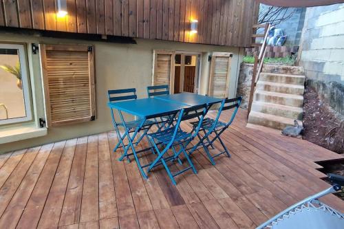 a blue table and chairs on a wooden deck at Appartement les petits Baobabs 2 in Mamoudzou
