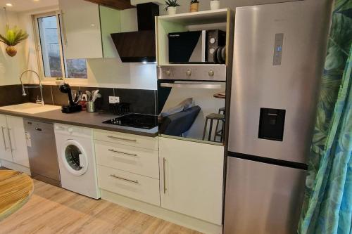 a kitchen with a refrigerator and a stove top oven at Appartement les petits Baobabs 2 in Mamoudzou