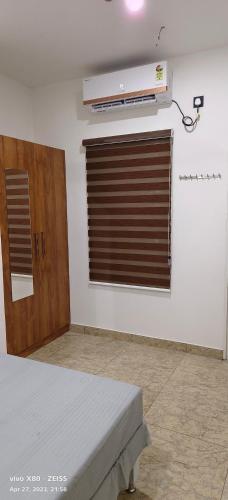 a room with a bed and a window with a heater at Oman house 2.O in Ernakulam