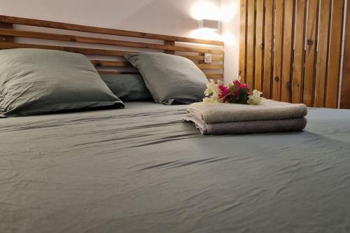 a bed with two pillows and a bouquet of flowers on it at Appartement les petits Baobabs 2 in Mamoudzou