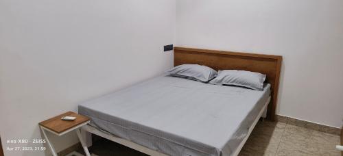 a bedroom with a bed with a wooden headboard at Oman house 2.O in Ernakulam