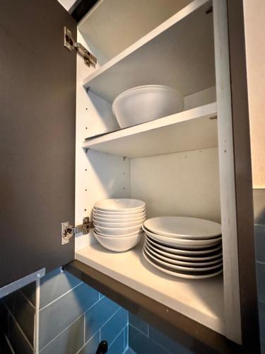 a cupboard with plates and bowls in it at Perfect family home next to London Bridge in London