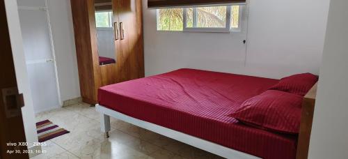 a red bed in a room with a window at Oman house 2.O in Ernakulam
